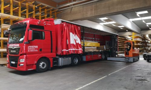 Seitliche Beladung eines Maintrans-LKW mit einem Gabelstapler, beladen wird Langgut im Teilladungsverkehr.